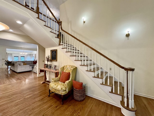 stairs featuring a towering ceiling and hardwood / wood-style flooring