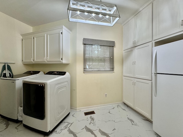 laundry area featuring washer and dryer and cabinets