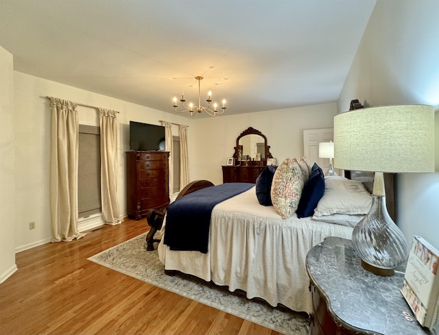 bedroom featuring wood-type flooring and a notable chandelier