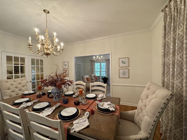 dining area featuring a chandelier, wood-type flooring, crown molding, and french doors