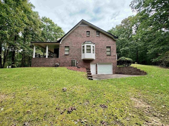 rear view of house with central AC unit, a garage, and a yard