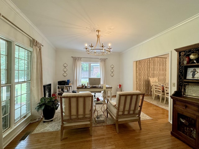 sitting room with hardwood / wood-style floors, crown molding, and a notable chandelier