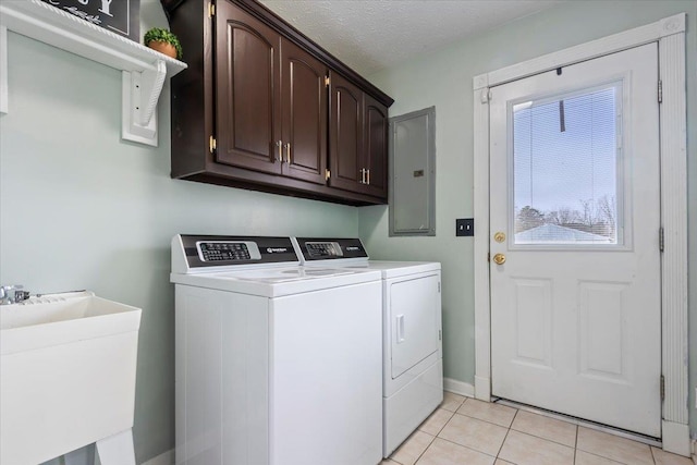 laundry area featuring sink, electric panel, cabinets, washer and dryer, and light tile patterned flooring