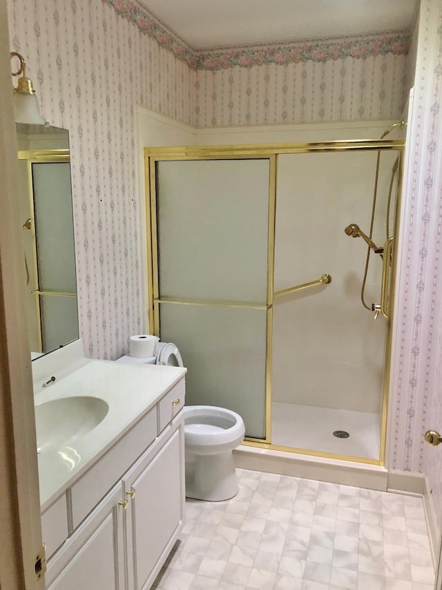 bathroom featuring vanity, toilet, and an enclosed shower