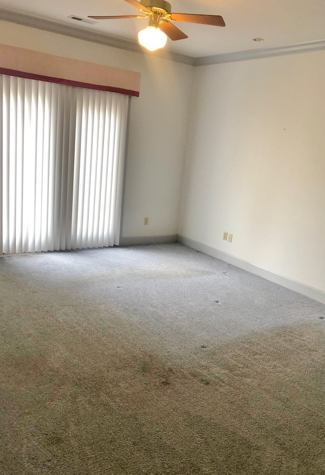 carpeted empty room with ceiling fan and crown molding