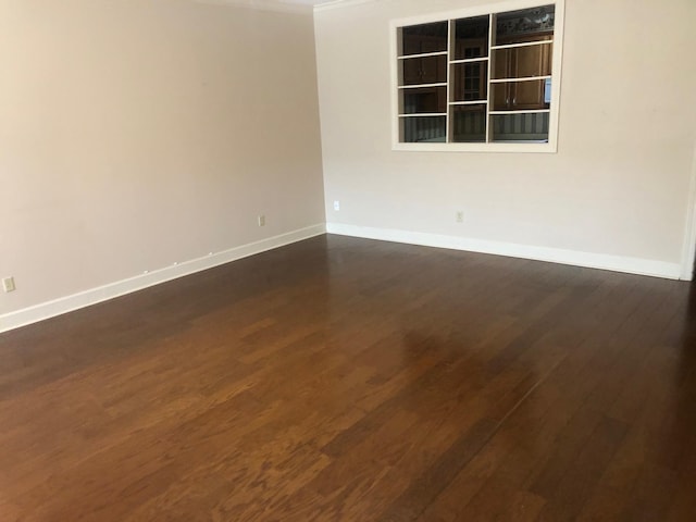 spare room with dark hardwood / wood-style flooring and crown molding