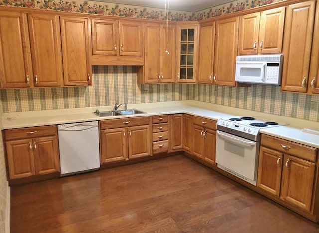 kitchen with dark hardwood / wood-style flooring, white appliances, and sink