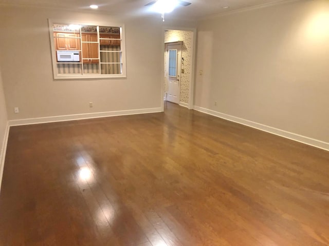 empty room featuring ceiling fan, dark hardwood / wood-style flooring, and crown molding