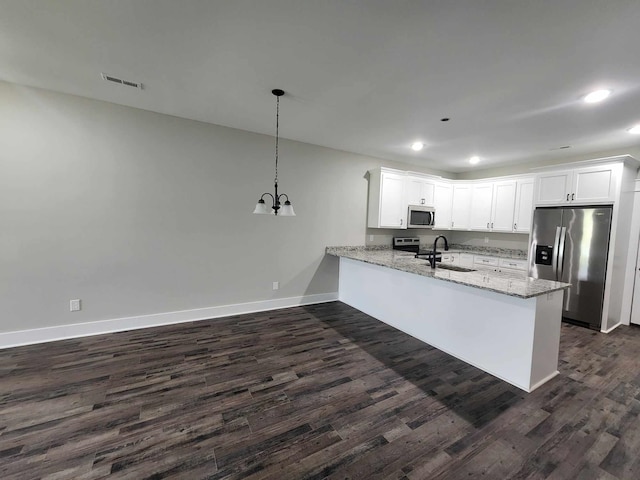 kitchen with kitchen peninsula, appliances with stainless steel finishes, sink, white cabinets, and hanging light fixtures