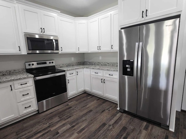 kitchen with light stone countertops, white cabinetry, dark wood-type flooring, and appliances with stainless steel finishes