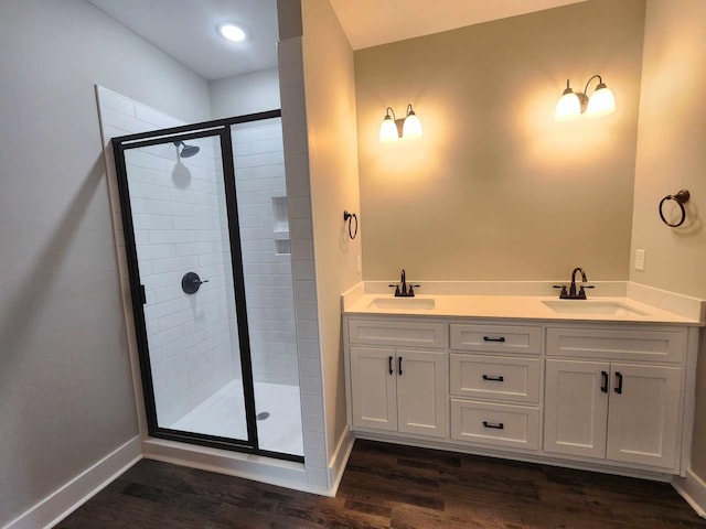 bathroom with hardwood / wood-style flooring, vanity, and an enclosed shower