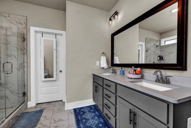  - full bath featuring marble finish flooring, baseboards, a marble finish shower, and double vanity