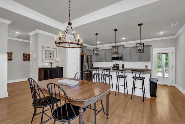  - dining room with a chandelier, light wood-style flooring, baseboards, recessed lighting, and crown molding