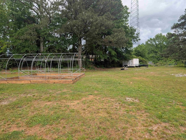 view of yard featuring an outdoor structure and a garden