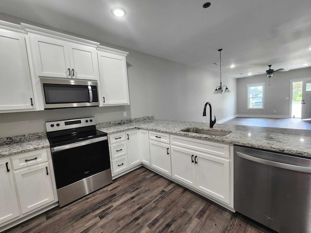 kitchen featuring stainless steel appliances, ceiling fan, sink, white cabinets, and hanging light fixtures