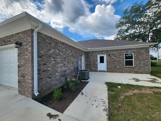 view of exterior entry with cooling unit and a garage