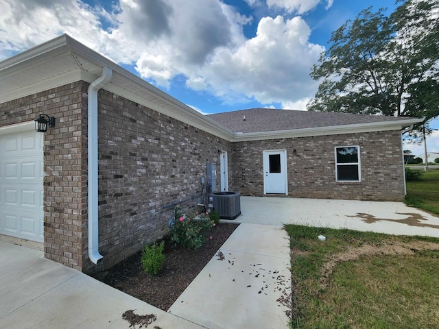 view of exterior entry with cooling unit and a garage