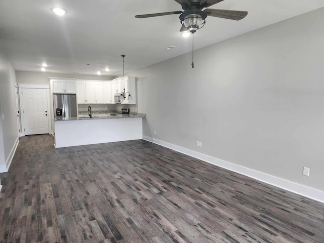 unfurnished living room with ceiling fan, dark wood-type flooring, and sink