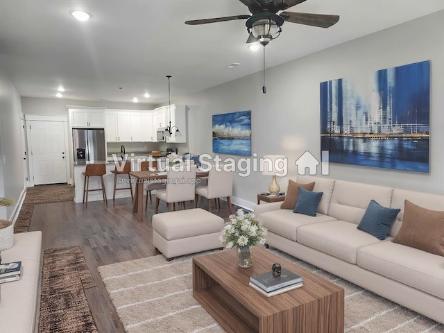 living room featuring ceiling fan, light hardwood / wood-style floors, and sink