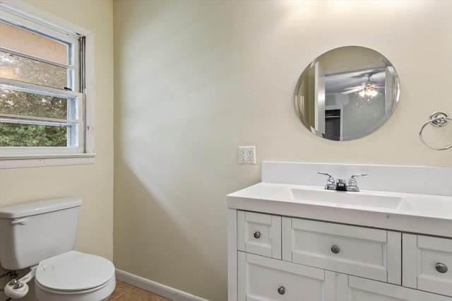 bathroom with ceiling fan, toilet, plenty of natural light, and vanity