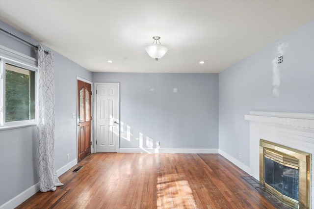 unfurnished living room featuring a fireplace and dark hardwood / wood-style flooring