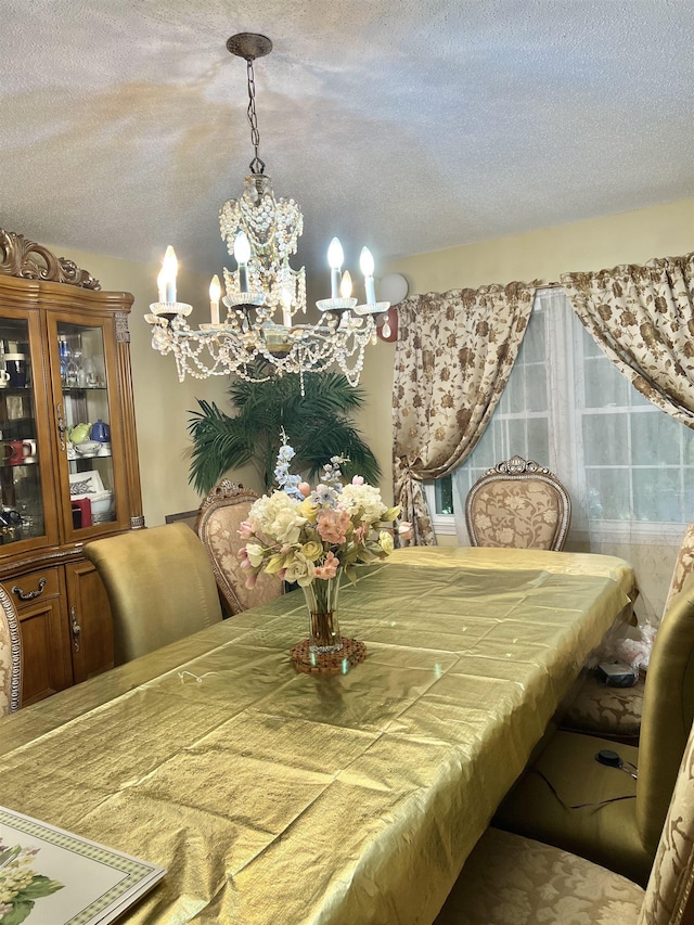  - dining space featuring a chandelier and a textured ceiling