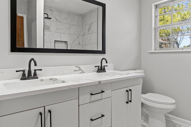  - full bath with marble look tile flooring, toilet, double vanity, a tile shower, and baseboards