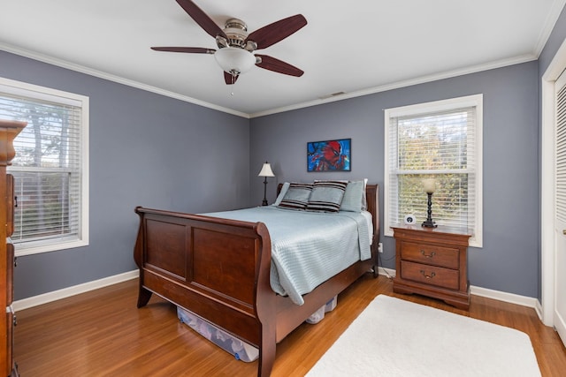 bedroom featuring hardwood / wood-style floors, ceiling fan, ornamental molding, and a closet