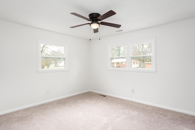 carpeted spare room with ceiling fan