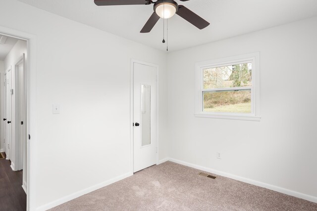 carpeted spare room with ceiling fan