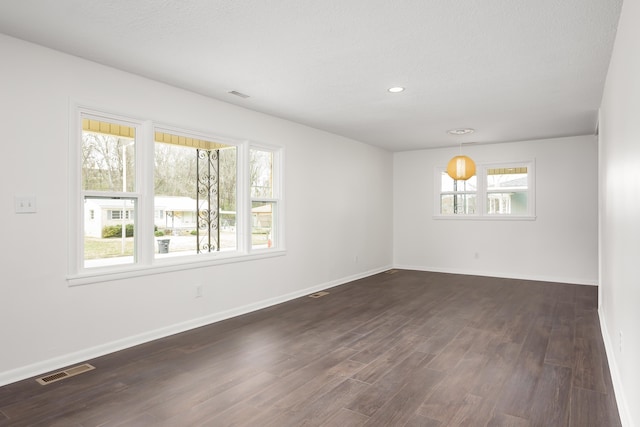 unfurnished room featuring dark hardwood / wood-style floors and a textured ceiling