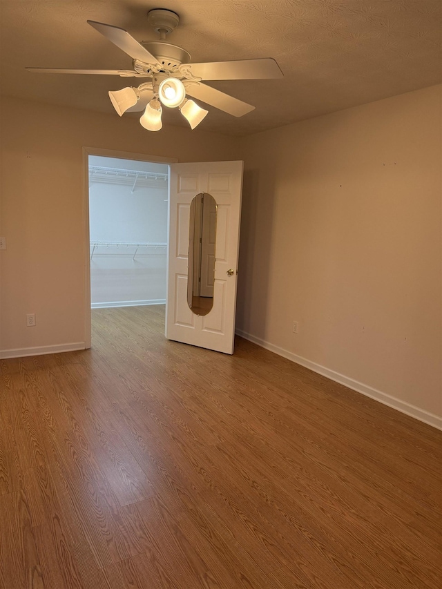 empty room with wood-type flooring and ceiling fan