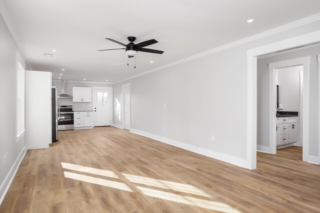 unfurnished living room with light hardwood / wood-style floors, ceiling fan, and ornamental molding