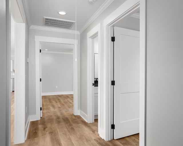 hall featuring crown molding and light hardwood / wood-style flooring