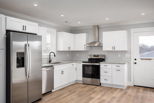 kitchen with white cabinets, wall chimney range hood, sink, and appliances with stainless steel finishes