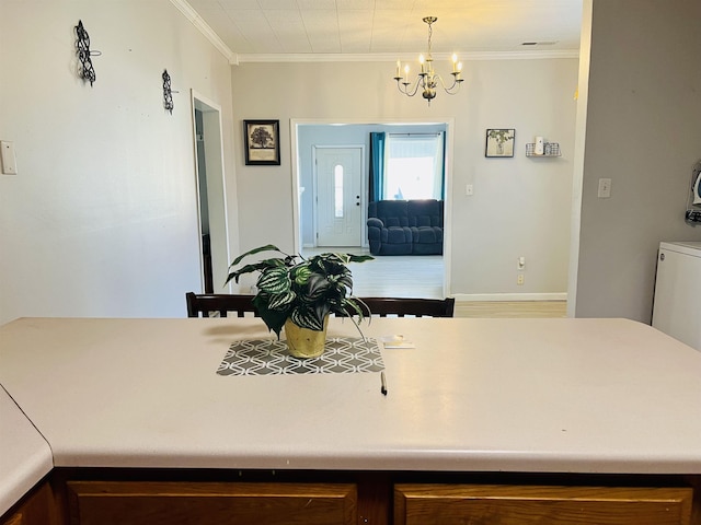 kitchen with decorative light fixtures, an inviting chandelier, and crown molding