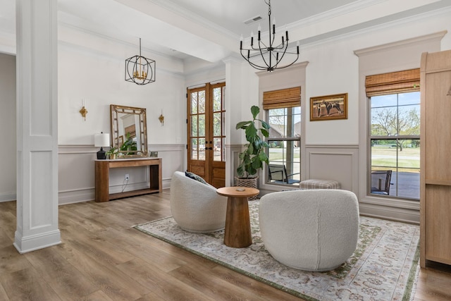 sitting room with visible vents, ornamental molding, a notable chandelier, and french doors
