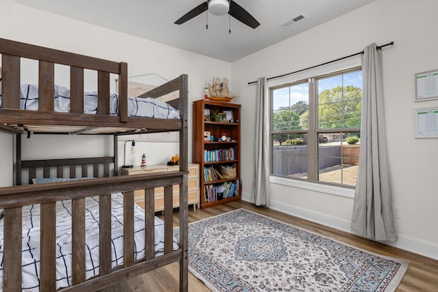 interior space featuring a ceiling fan, baseboards, visible vents, and wood finished floors