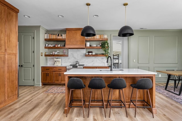 kitchen with a sink, decorative backsplash, open shelves, and light wood-style flooring
