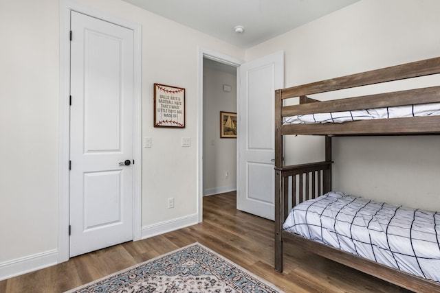 bedroom featuring baseboards and wood finished floors