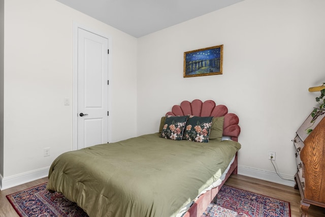 bedroom featuring baseboards and wood finished floors