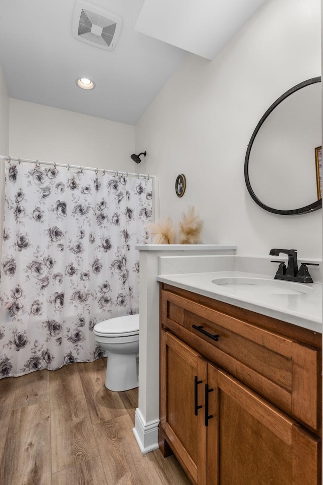 bathroom with visible vents, vanity, wood finished floors, toilet, and a shower with curtain