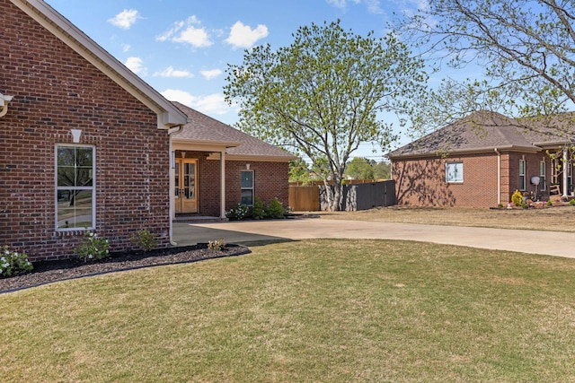 view of yard featuring fence and concrete driveway