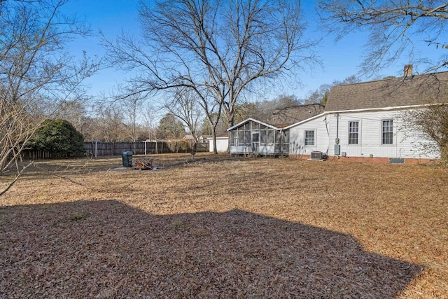 view of yard with central AC and a sunroom