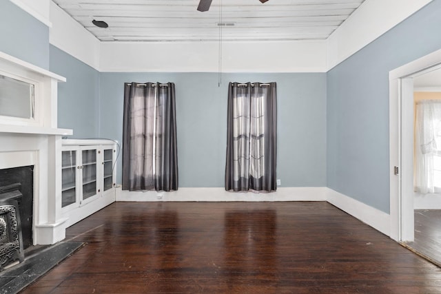 unfurnished living room featuring ceiling fan and dark hardwood / wood-style flooring