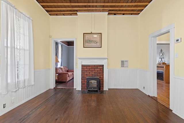 unfurnished living room featuring beamed ceiling, dark hardwood / wood-style floors, and wood ceiling