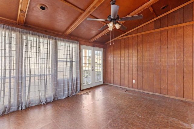 spare room with vaulted ceiling with beams, wooden walls, french doors, and ceiling fan