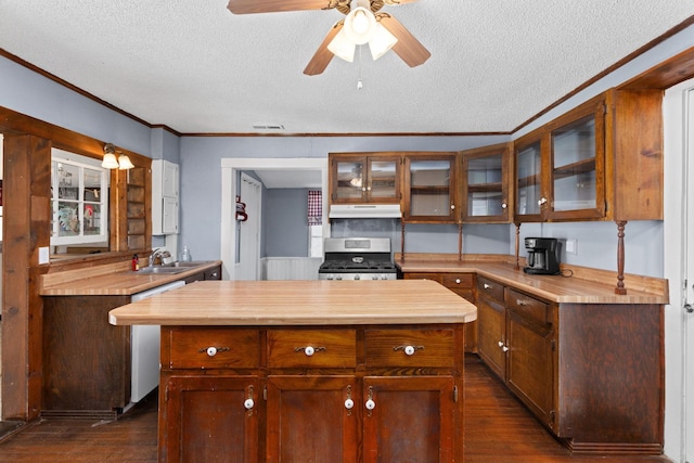 kitchen featuring crown molding, stainless steel appliances, a center island, and dark wood-type flooring