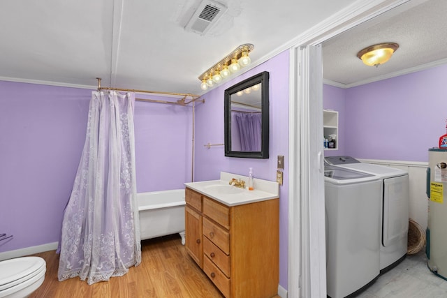 full bathroom featuring ornamental molding, vanity, electric water heater, washer and clothes dryer, and hardwood / wood-style floors