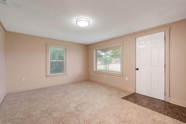  - carpeted spare room featuring a textured ceiling and baseboards